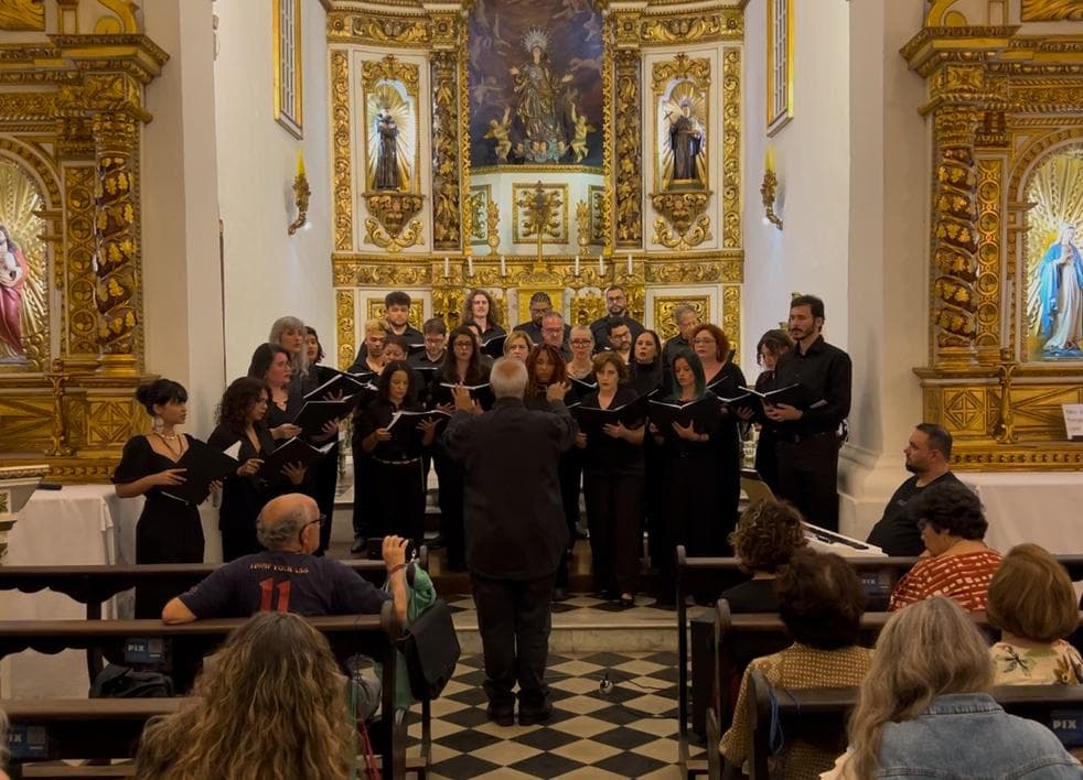 Opus Liberi cantando diante de um altar dourado, regido pelo maestro